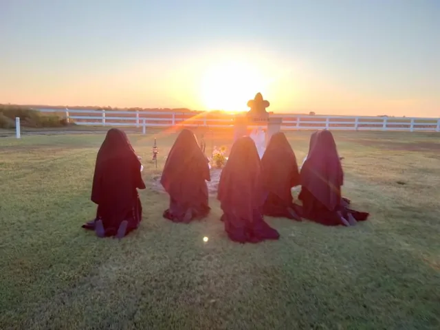Sisters praying for the faithful departed.